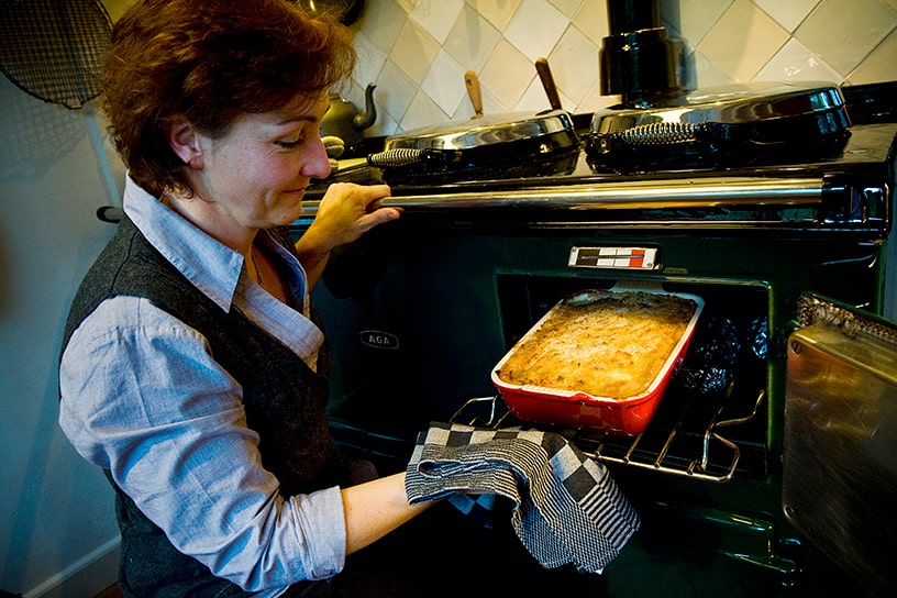 Saskia Schepers voor geopend AGA fornuis met ovenschaal