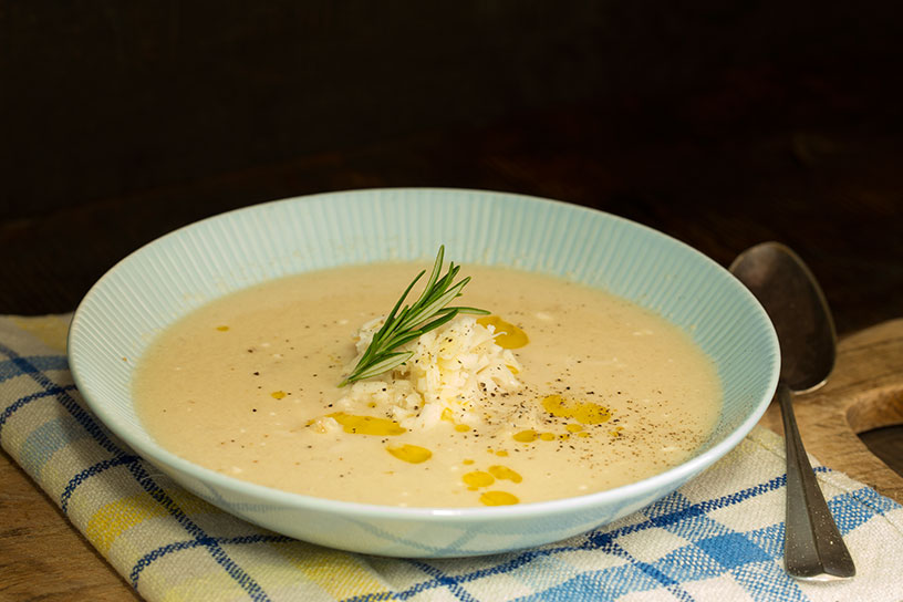 Bord met bloemkool-kaassoep op tafel