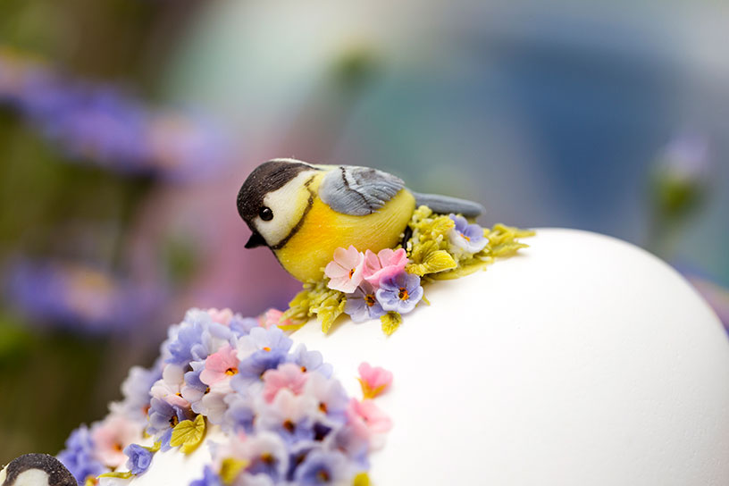 Ei versierd met bloemen en vogeltje van klei.