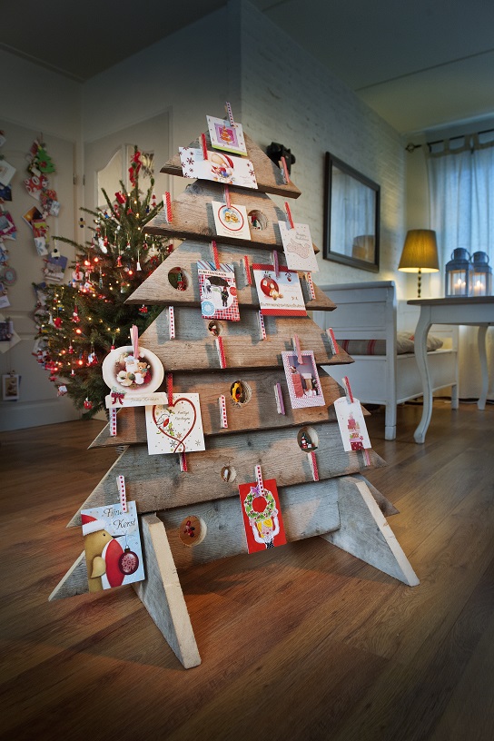 Een steigerhouten kerstboom gevuld met kerstkaarten.