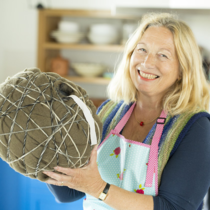 Vrouw toont het tussenresultaat van het vilten vogelhuis.