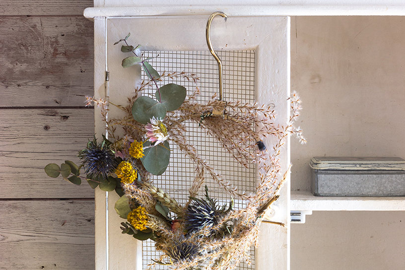 Droogbloemen die hangen aan een kastdeur